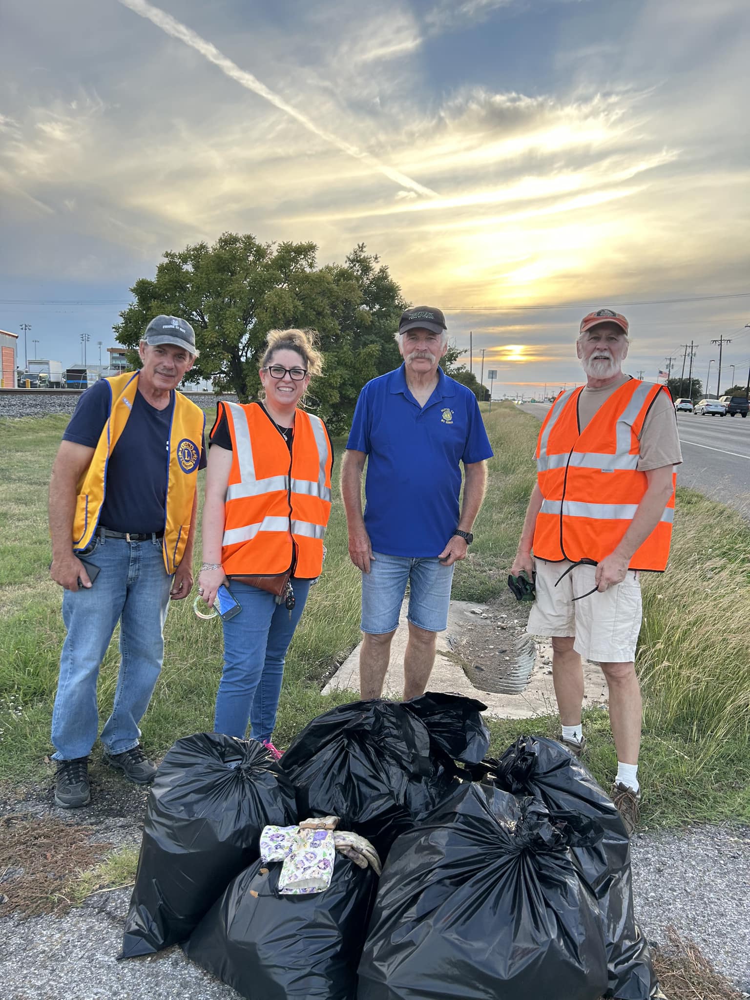 Hutto Lions Club member pose with large bags of garbage after road clean up