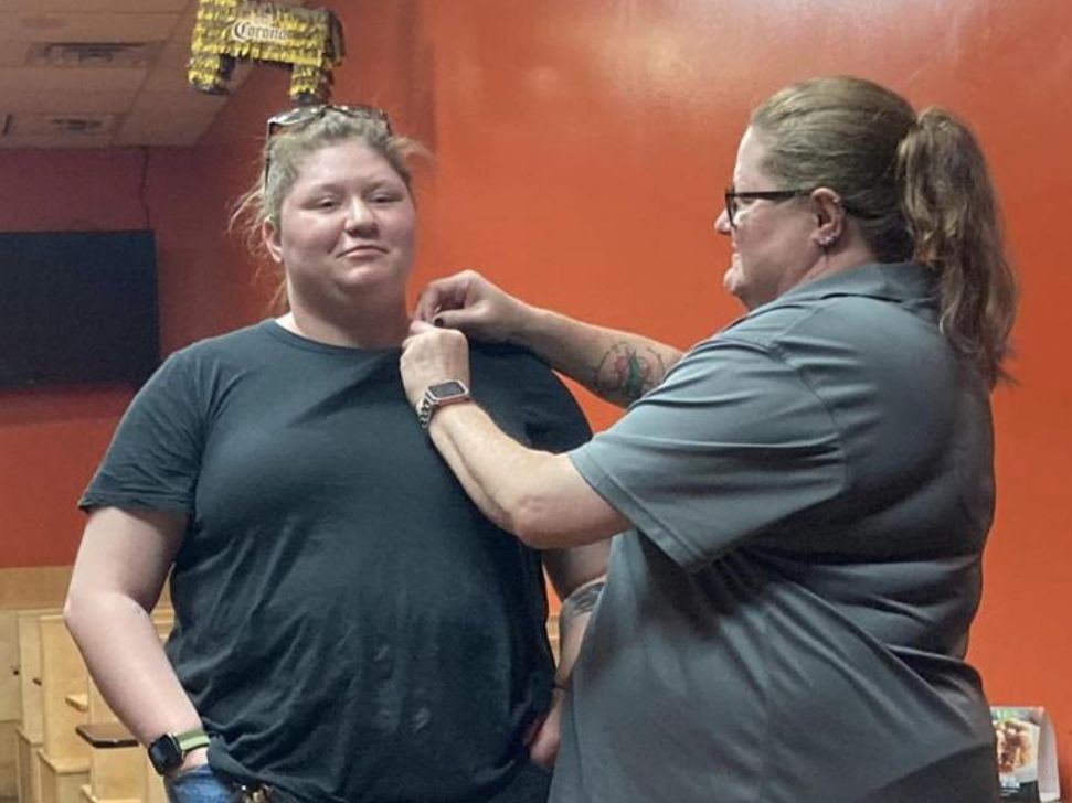 Woman gets pinned as a new Lions Club member during ceremony