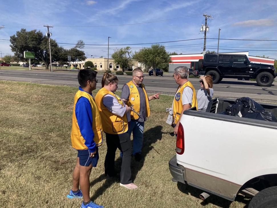 Hutto Lions Club members chat on the side of the road